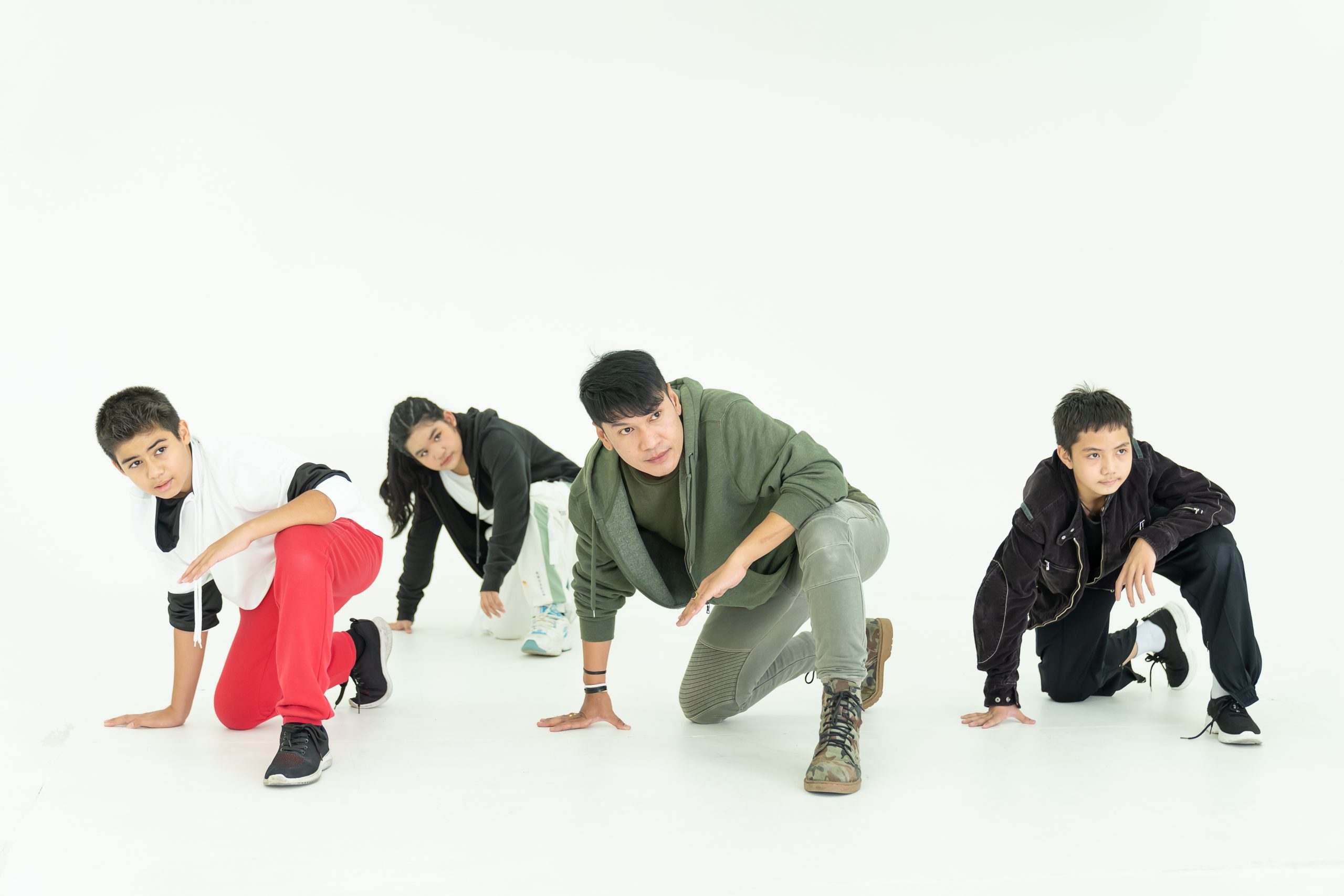 Asian male teacher and group of children show dancing in dance center on white background